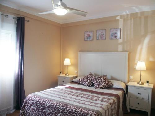 1 dormitorio con 1 cama con 2 mesitas de noche y 2 lámparas en Benavente, en Ayamonte
