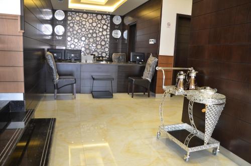 a waiting room with a table and chairs and a counter at Reef Hotel Aparts (Tabasum Group) in Ajman 