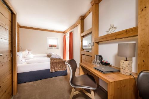 a bedroom with a bed and a desk with a computer at Dein Engel in Oberstaufen
