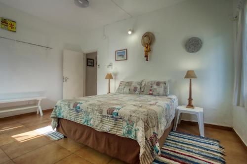 a bedroom with a bed and a window and a bed sidx sidx sidx at Ilha Azul House in Ponta do Ouro