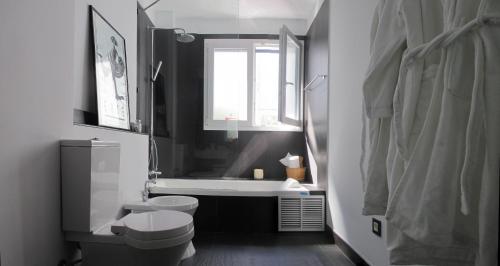 a bathroom with a tub and a toilet and a sink at B&B Casa Alfareria 59 in Seville