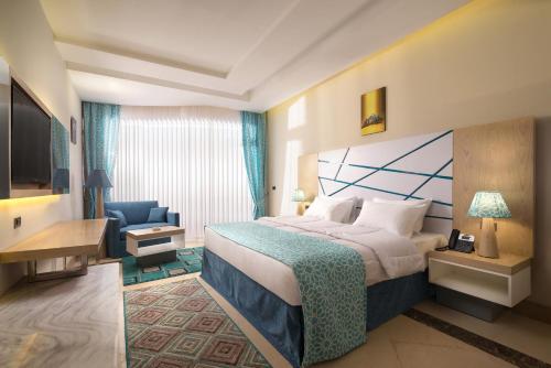 a hotel room with a bed and a blue chair at Gravity Hotel & Aqua Park Sahl Hasheesh Families and Couples Only in Hurghada