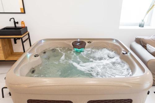 a bath tub filled with water in a living room at Love room Jacuzzi Sauna Privatif Marseille in Marseille