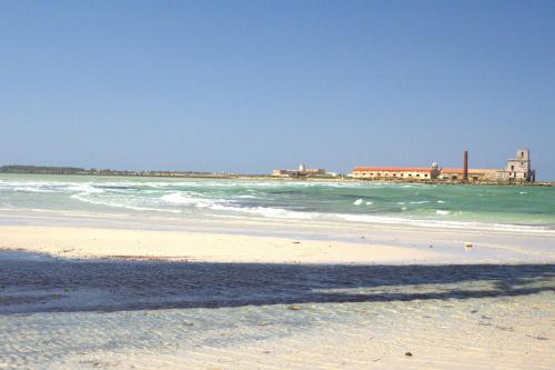 a beach with the ocean and buildings in the background at B&B Sbarco dei 1000 in Marsala