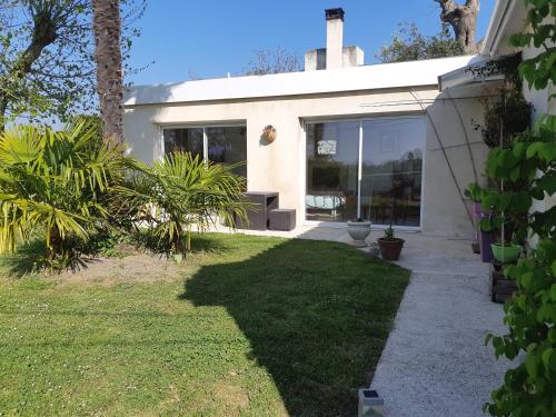 a white house with a garden and a lawn at L'Escale Bellevue in Blaye