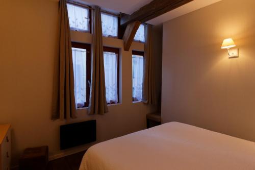 Tempat tidur dalam kamar di Appart'Hôtel Sainte Trinité