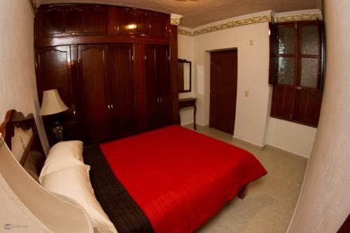 a bedroom with a bed with a red blanket at Cuartel 1914 - Hotel Boutique in Zacatecas