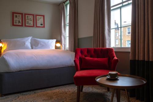 a hotel room with a bed and a chair and a table at Home Grown - Private Member's Club in London