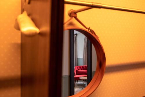 a mirror with a red chair in a room at Home Grown - Private Member's Club in London