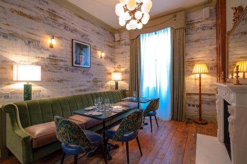 a living room with a green couch and a table and chairs at Home Grown - Private Member's Club in London