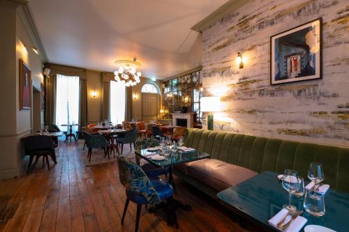 a restaurant with a green couch and tables and chairs at Home Grown - Private Member's Club in London