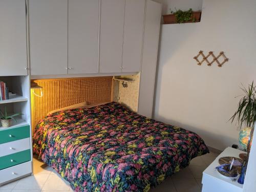 una camera da letto con un copriletto colorato di Il Nido - Casa Vacanze & Galleria d'Arte a Orbetello
