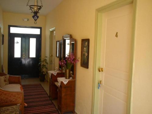a hallway with a door and a room with a vase of flowers at Hariklia Rent Rooms in Zarós