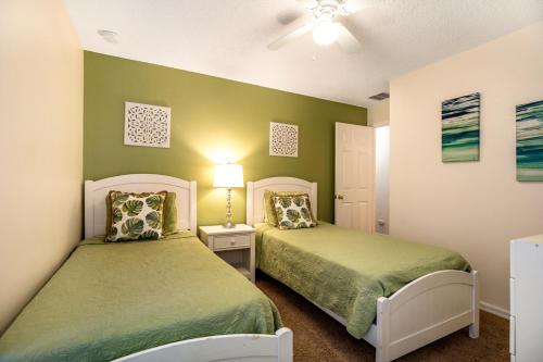 基西米Disney Area Villa South-Facing Pool and Spa Game Room的一间绿墙房间里有两张床