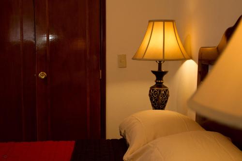 a lamp sitting next to a bed in a room at Cuartel 1914 - Hotel Boutique in Zacatecas