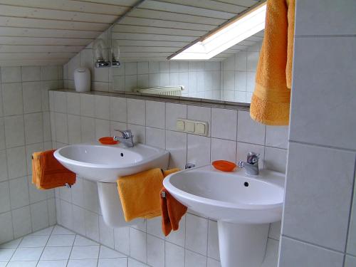 a white bathroom with two sinks and a mirror at Ferienwohnung Schartner in Eggstätt