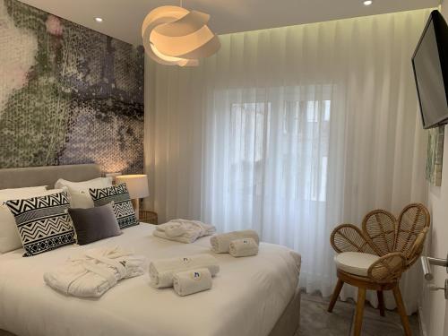 a bedroom with a white bed with towels on it at Cascais Downtown Premium Apartment 2 in Cascais