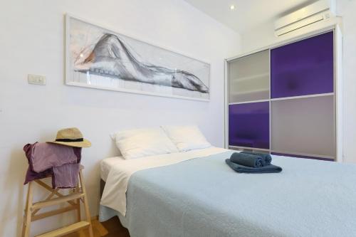 a bedroom with a bed and a hat on a ladder at Lovely Rita's Sibenik - apartment city center in Šibenik