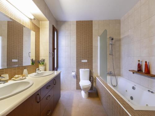 een badkamer met 2 wastafels, een toilet en een douche bij Troodos Riverside Cottage in Kato Amiandos