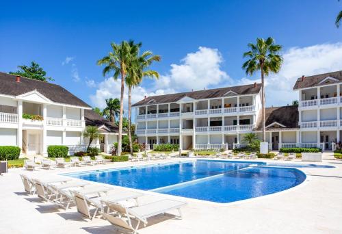 a large white swimming pool in front of a house at Albachiara Hotel - Las Terrenas in Las Terrenas