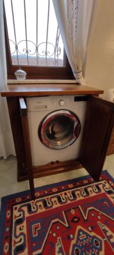 a washing machine in a room with a window and a rug at Elegante Appartamento in Sangano