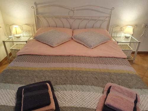 a bedroom with a bed with two pillows and two lamps at Apartma Cerknica in Cerknica
