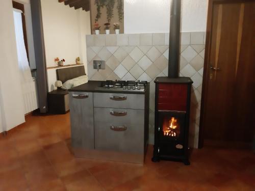a kitchen with a stove with a fire in it at La casa in giardino in Volterra