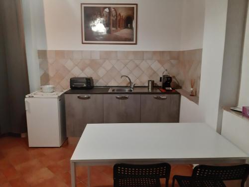 a kitchen with a white table and a sink at La casa in giardino in Volterra