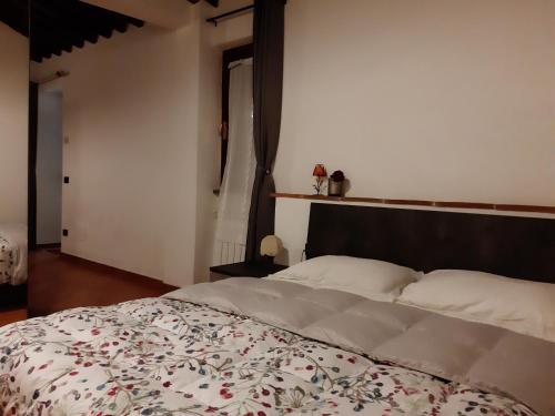 a bedroom with a large bed with a floral bedspread at La casa in giardino in Volterra