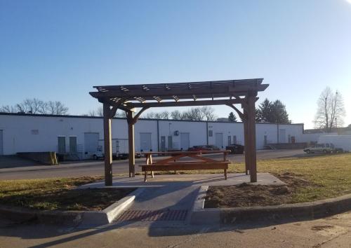 a bench in a park with a wooden canopy at Rodeway Inn Urbana Champaign University Area in Champaign