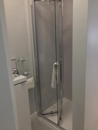 a shower with a glass door in a bathroom at Cosy stylish 1-Bed Apartment in South Armagh in Cullyhanna