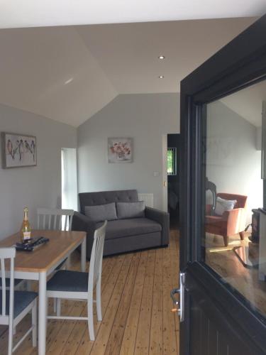 a living room with a couch and a table at Cosy stylish 1-Bed Apartment in South Armagh in Cullyhanna