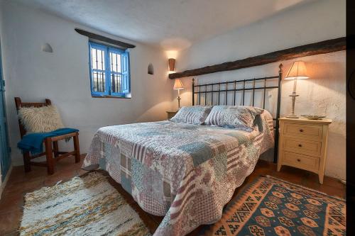a bedroom with a bed and a chair and a window at Townhouse Sleeps 6 with Private Pool in Gaucín