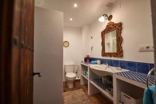 a bathroom with a sink and a toilet and a mirror at Townhouse Sleeps 6 with Private Pool in Gaucín