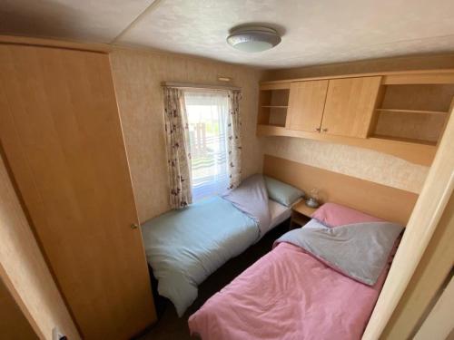 米勒姆的住宿－Lake District Static Caravan Lakeside Cumbria，小房间设有两张床和窗户