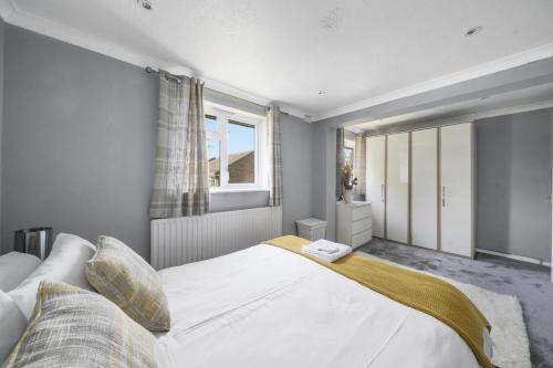 a bedroom with a large white bed and a window at Spacious 5-Bed House in Aylesford in Snodland
