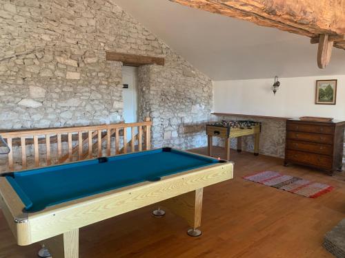 einen Billardtisch in einem Zimmer mit einer Steinmauer in der Unterkunft Country Villa for 18 Pool Cinema Football Pitch in Verteillac