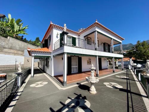 a white house with a balcony on a street at Classic Tranquil Madeiran 4-Bedroom Villa Funchal in Funchal