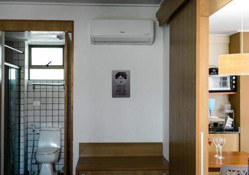 a bathroom with a toilet and a sink at Flat Beach Class Muro Alto 1107 in Porto De Galinhas