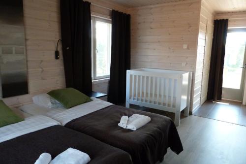 a bedroom with two beds and a baby crib at Tallusniemi Villas in Oravi