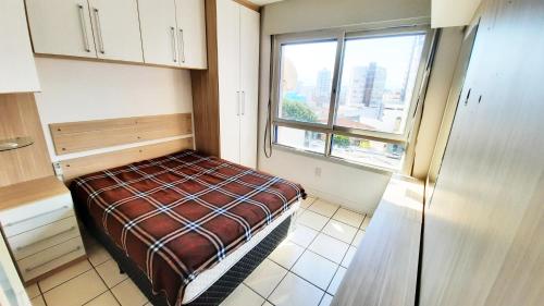 Habitación pequeña con cama y ventana en Apartamento 308, Marina, Centro - Torres - RS, en Torres