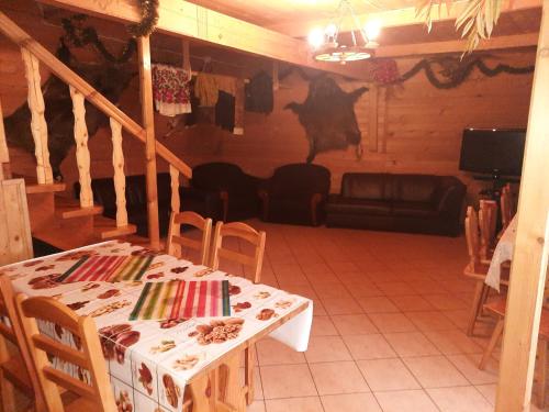 a living room with a table and a cow on the wall at Kwatery Prywatne U Bachledów in Zakopane
