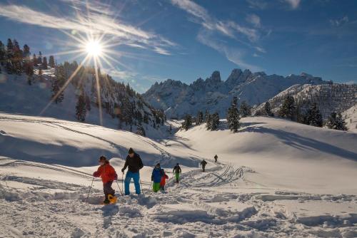 a group of people skiing down a snow covered slope at Hotel Erika in Braies