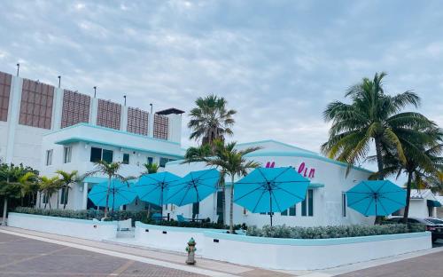 un bâtiment avec des parasols bleus devant lui dans l'établissement The Marlin Beachside, à Hollywood