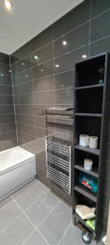 a tiled bathroom with a tub and a toilet in a room at Smart Town Centre Apartments in Northampton
