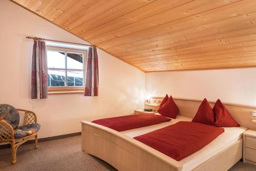 a bedroom with a bed and a window and a chair at Ladinser Hof Reiterstube in Castelrotto