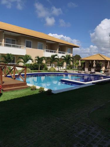 a large swimming pool in front of a building at Charming Guarajuba in Guarajuba