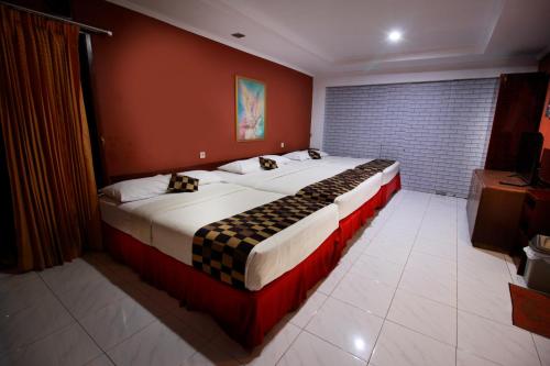 a bedroom with a large bed in a room at Fora Guest House Taman Lingkar in Bandung
