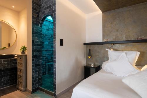 a bedroom with a bed and a shower at Domaine du Haut Jardin Hôtel & Chalets Spa Privé in Rehaupal