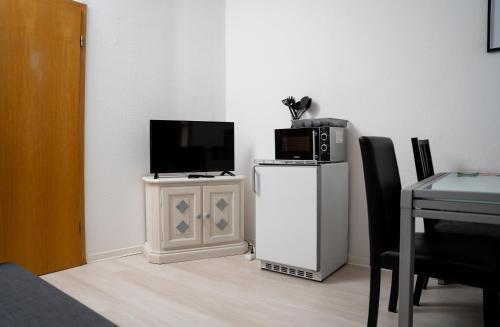 a room with a tv and a microwave on a cabinet at 3 Zimmer Wohnung für max. 5 Personen in Alzey